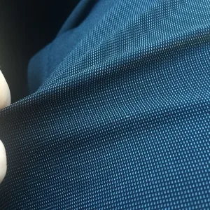 Close-up of a navy blue woven polyester fabric being stretched between two fingers