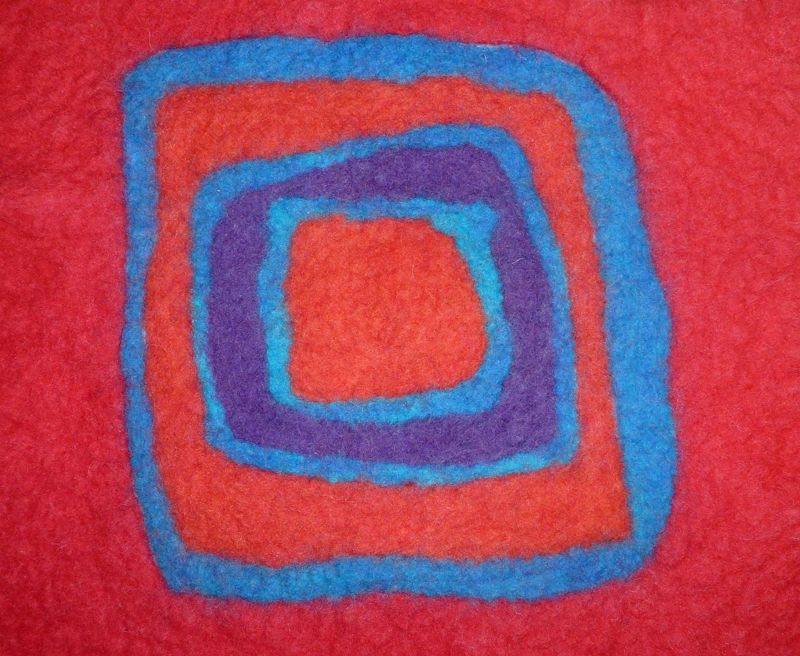 Red felt with a blue and purple square spiral felted into its surface