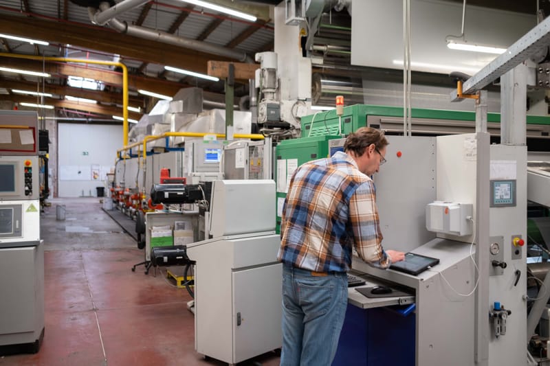 textile production facility with workers monitoring digital dashboards