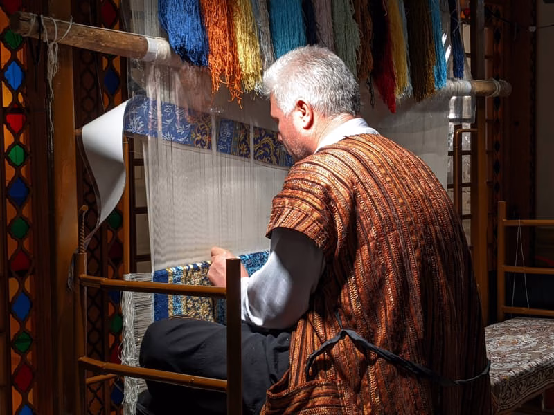 Artisan weaving traditional fabric on a backstrap loom in Latin America or Southeast Asia Artisan weaving traditional fabric on a backstrap loom in Latin America or Southeast Asia